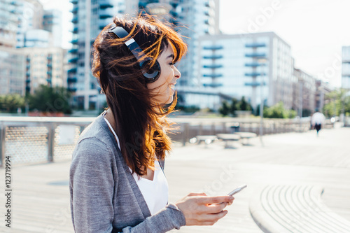 Young Woman Listening Music with Headphones and Mobile Phone  . New York City US