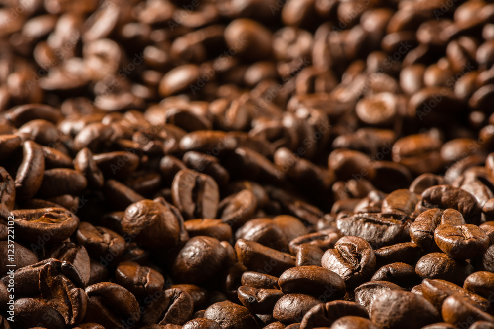 Fototapeta premium Dark roasted coffee beans filling fram in dramatic light