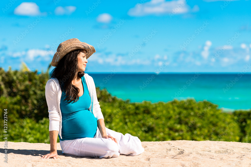 Pregnant woman lying on beach