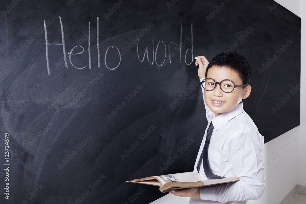 Wunschmotiv: Boy holds book and writes Hello World #123724579