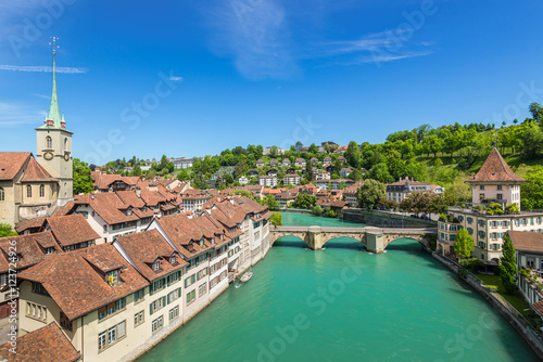 A wide-angle view of the Aare River, Сhurch, bridge and houses with tiled rooftops at Bern, Switzerland