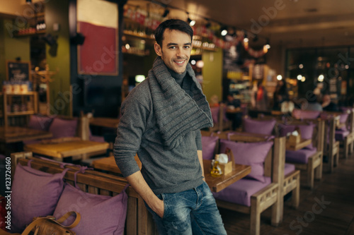 Young handsome man standing and posing in the restaurant