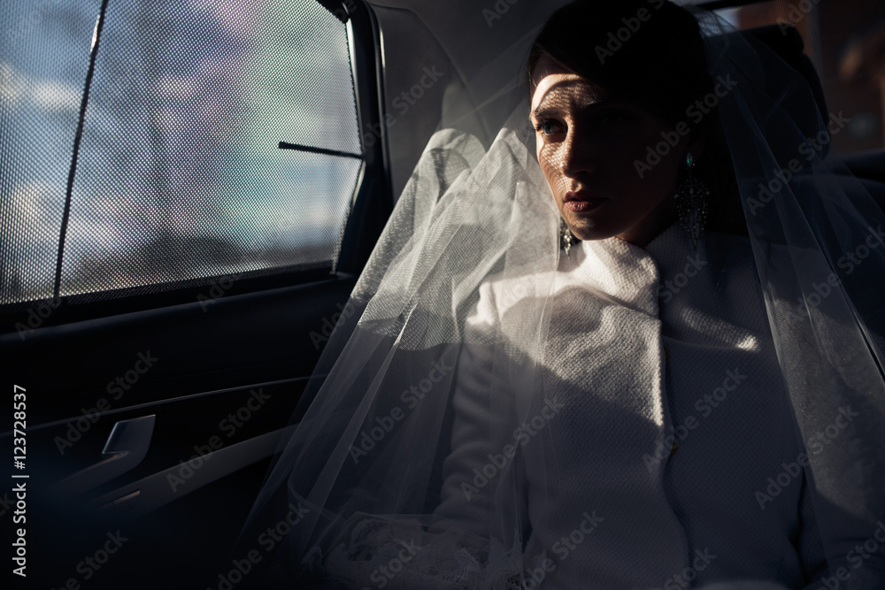 Sun shines over bride's face while she drives in a car