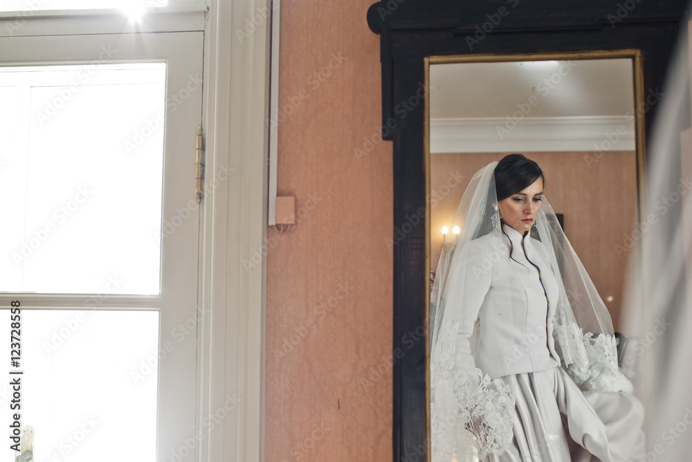 A reflection of thoughtful bride in an old-fashioned mirror