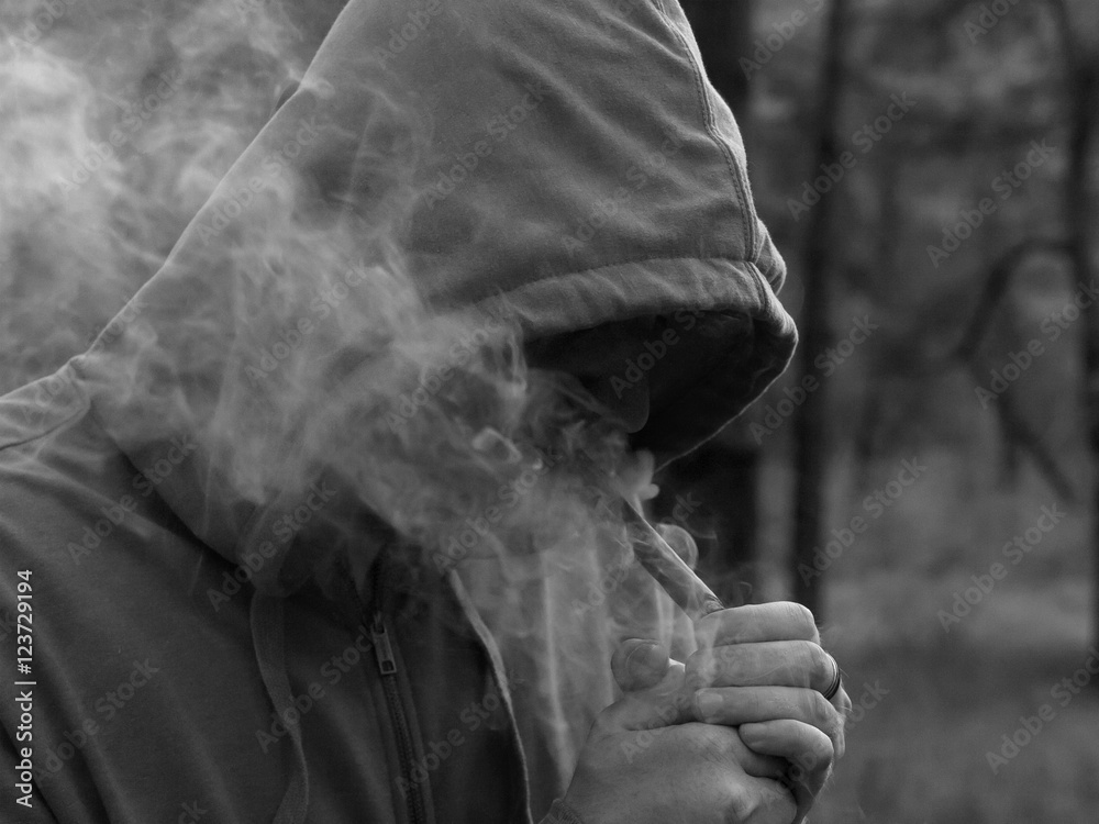 Man Smoking a cigar, produces a white smoke
