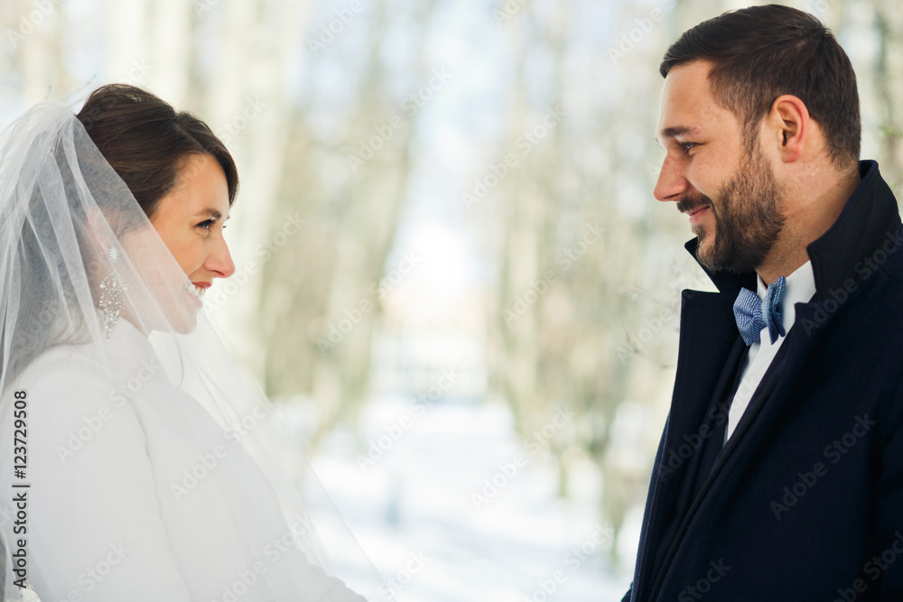 Merry wedding couple stands in winter coats during the ceremony Merry wedding couple stands in winter coats during the ceremony