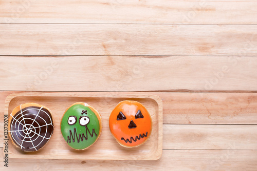 halloween donuts in wooden tray on wooden background.
