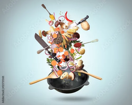 Obraz Duża żelazna patelnia z spadającymi warzywami i grzybami