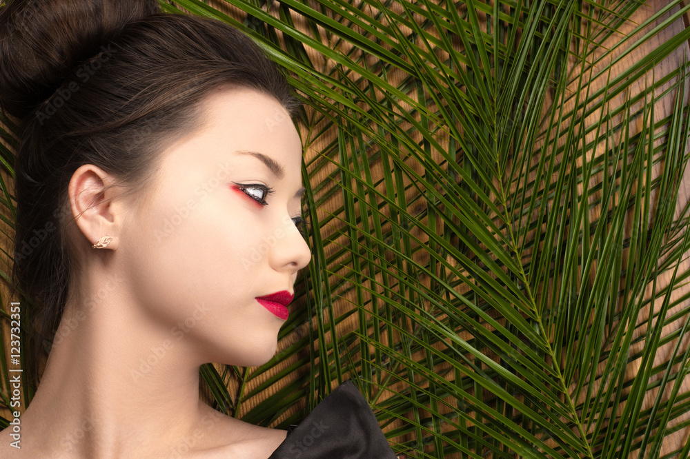 profile face attractive young Korean girl with tropical bushes profile face attractive young Korean girl with tropical bushes