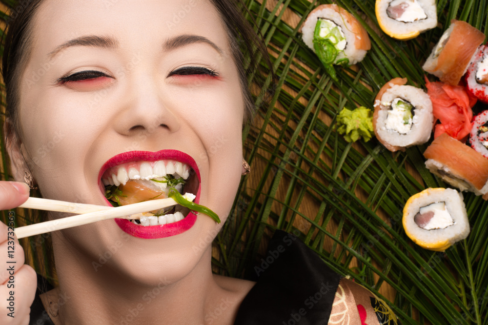 beautiful smiling young Korean girl eating sushi rolls Stock Photo ...
