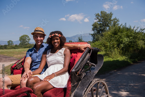 multiethnic couple sitting in a horse carriage
