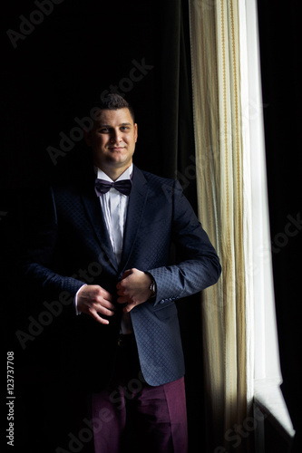 Handsome groom in the stylish tuxedo