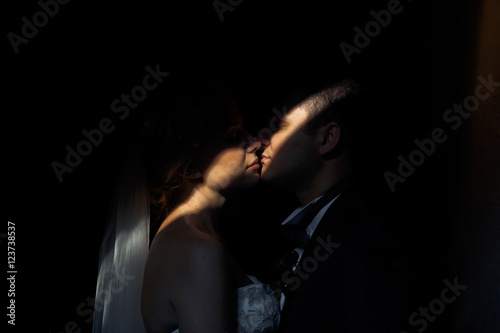 Dark room and sensual newlyweds