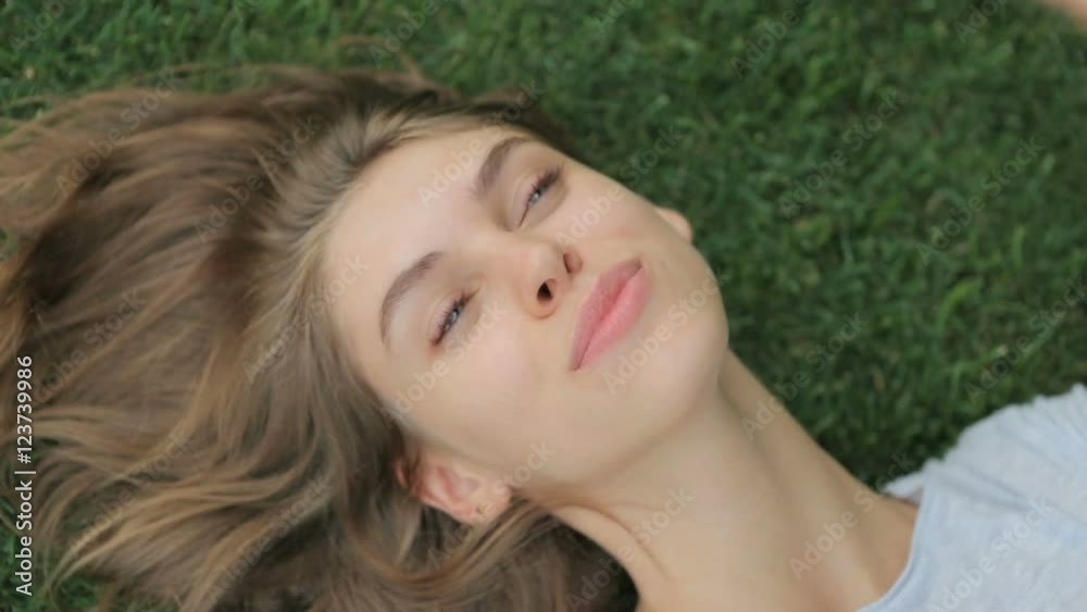 Young , attractive girl lying on the grass enjoying the outdoors Young , attractive girl lying on the grass enjoying the outdoors