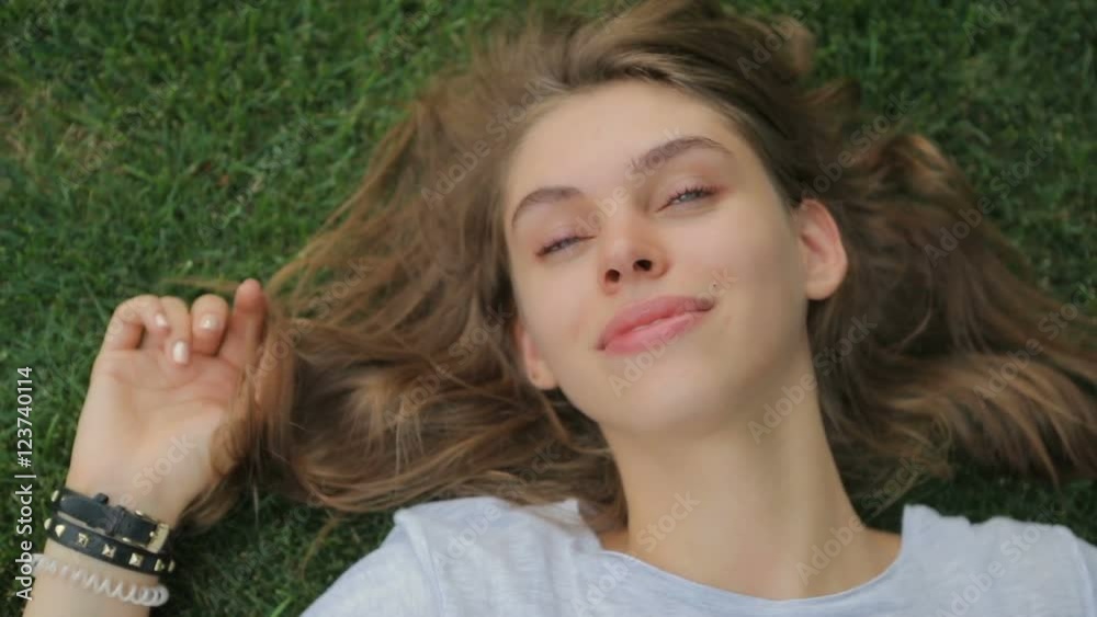 Young , attractive girl lying on the grass enjoying the outdoors Young , attractive girl lying on the grass enjoying the outdoors