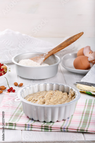Raw batter for almond cake and ingredients for baking