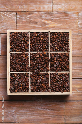 Roasted coffee beans in wooden basket on brown table