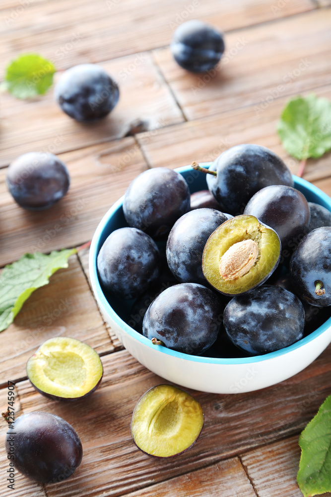 Tasty and ripe plums on brown wooden table Tasty and ripe plums on brown wooden table