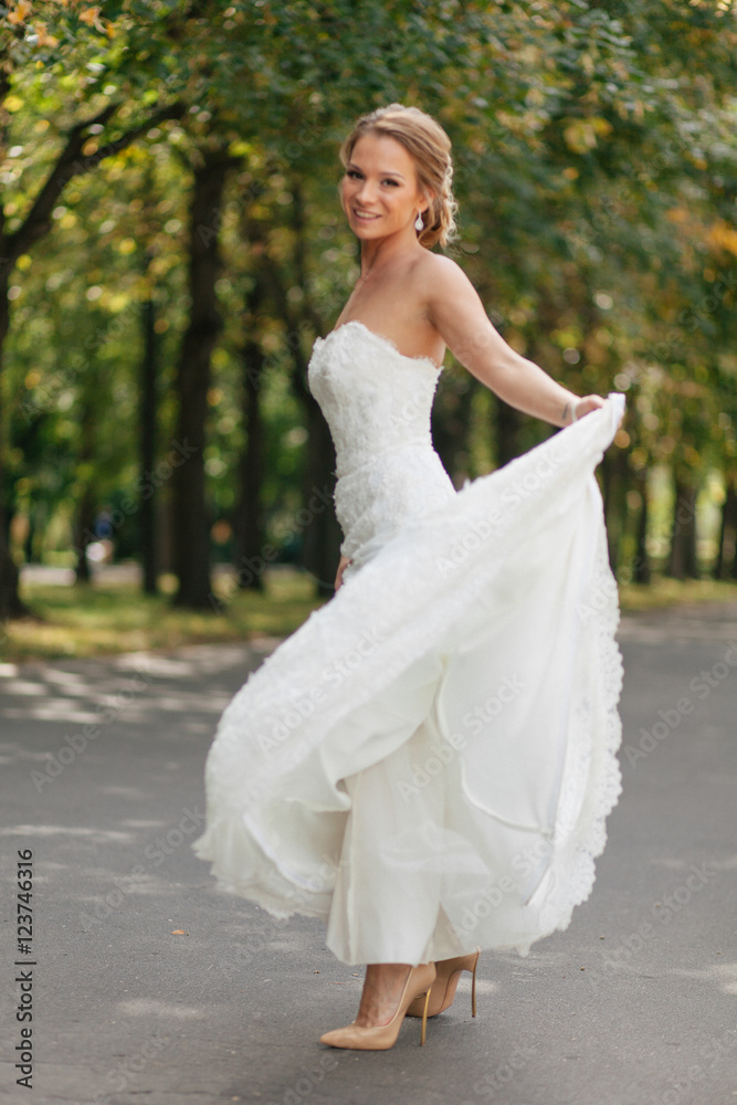 Lovely bride is turning around in the park