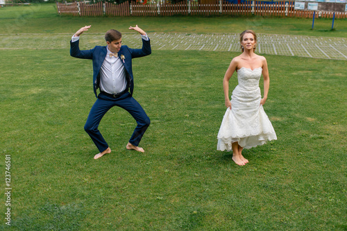 Ridiculous newlyweds on the green grass