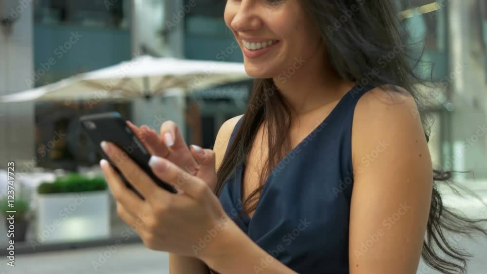 Attractive business woman commuter using smartphone walking in city Attractive business woman commuter using smartphone walking in city