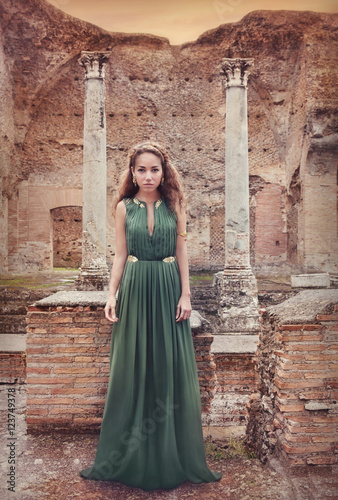 Beautiful woman near ancient Roman ruins, in long dress