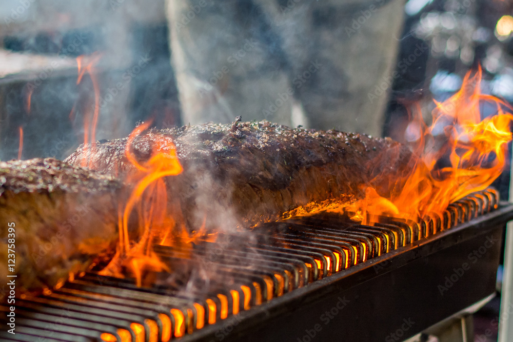 Naklejka premium Grilling entrecote on a barbecue with fire