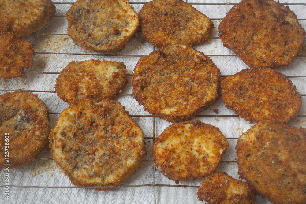 Slices of fried breaded eggplant on a tray. Slices of fried breaded eggplant on a tray.