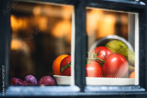 Still life of fruit and vegetables in a window with tomatoes in the afternoon