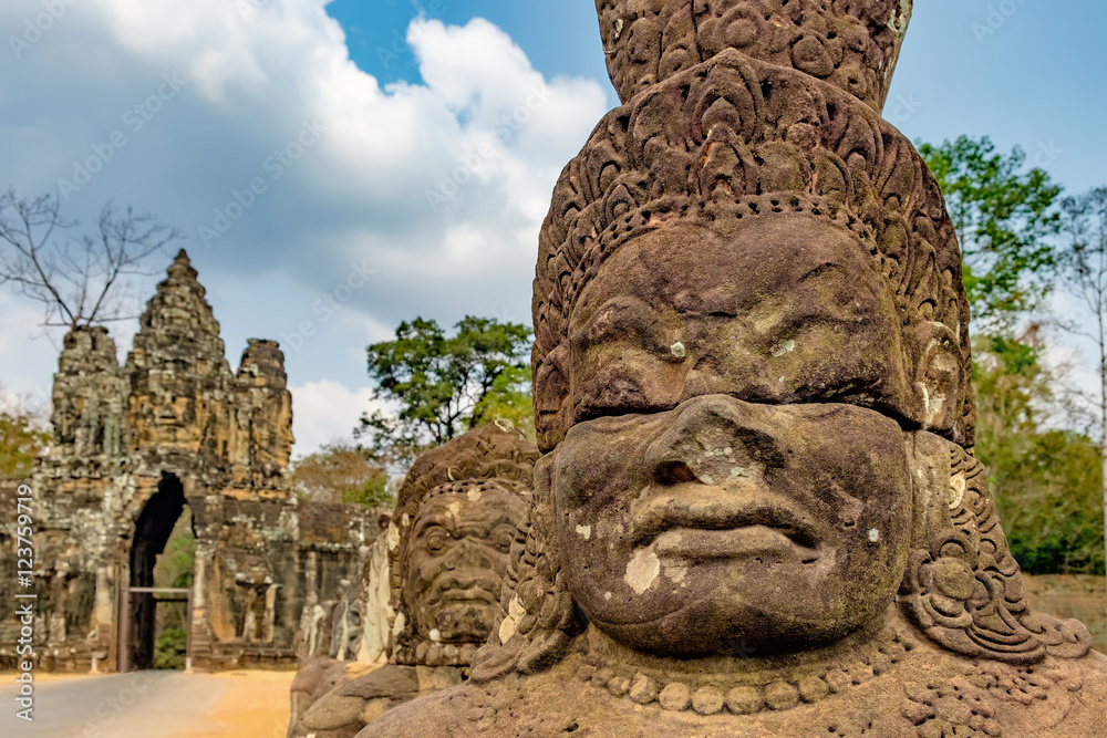 South gate to Angkor Thom and the faces of stone giants guarding the entrance, Cambodia.