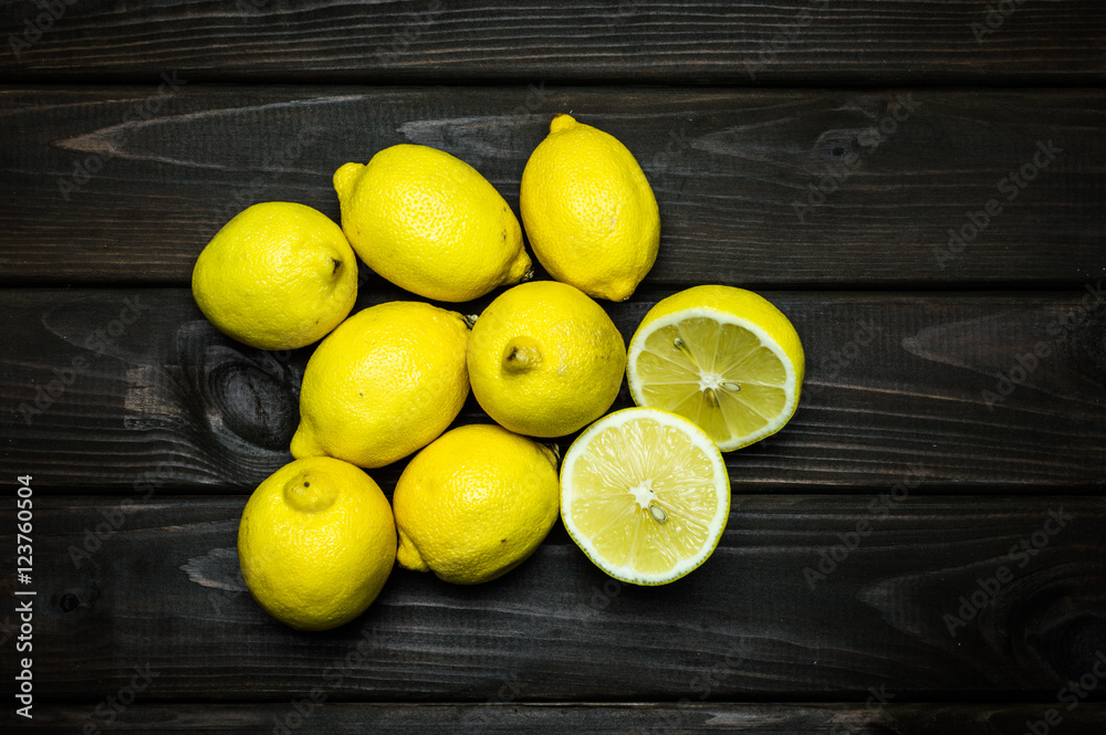 Whole and cut lemons on grey wooden surface Whole and cut lemons on grey wooden surface