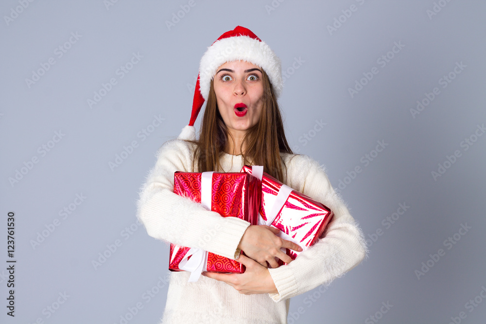 Woman in red christmas hat holding presents Woman in red christmas hat holding presents