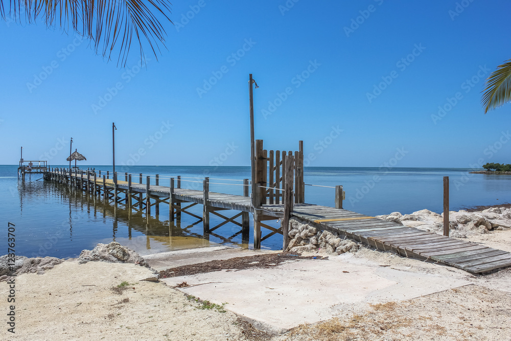 Typical wooden jetty of the Key Islands in Florida, United States. Tropical landscape of Keys in a sunny day. Summertime.