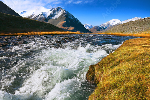 landscape of mountain peaks and swift rivers in the fall