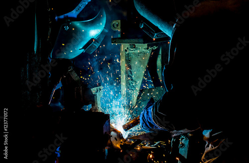 The movement of workers with protective mask welding metal.
