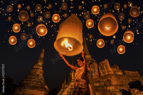 Thai woman with floating lamp in Ayuthaya historical park, with Wat Phra Sri Sanphet temple background, Thailand