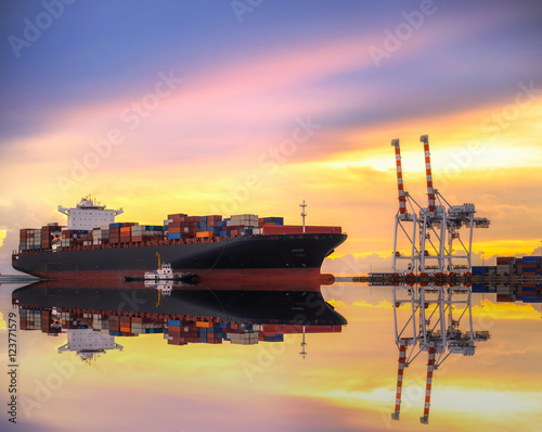 Container Cargo freight ship with working crane bridge in shipyard at dusk for Logistic Import Export background