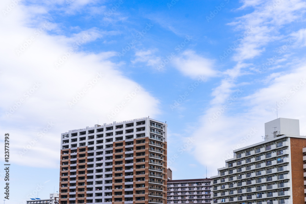 Fototapeta premium Real estate image, tower apartment building against blue sky