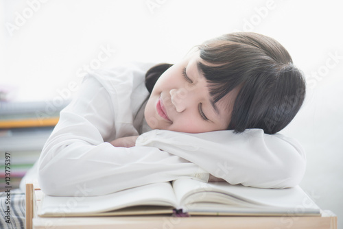 Beautiful Asian girl sleeping on the books