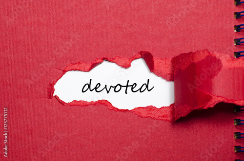 The word devoted appearing behind torn paper