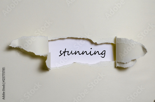 The word stunning appearing behind torn paper