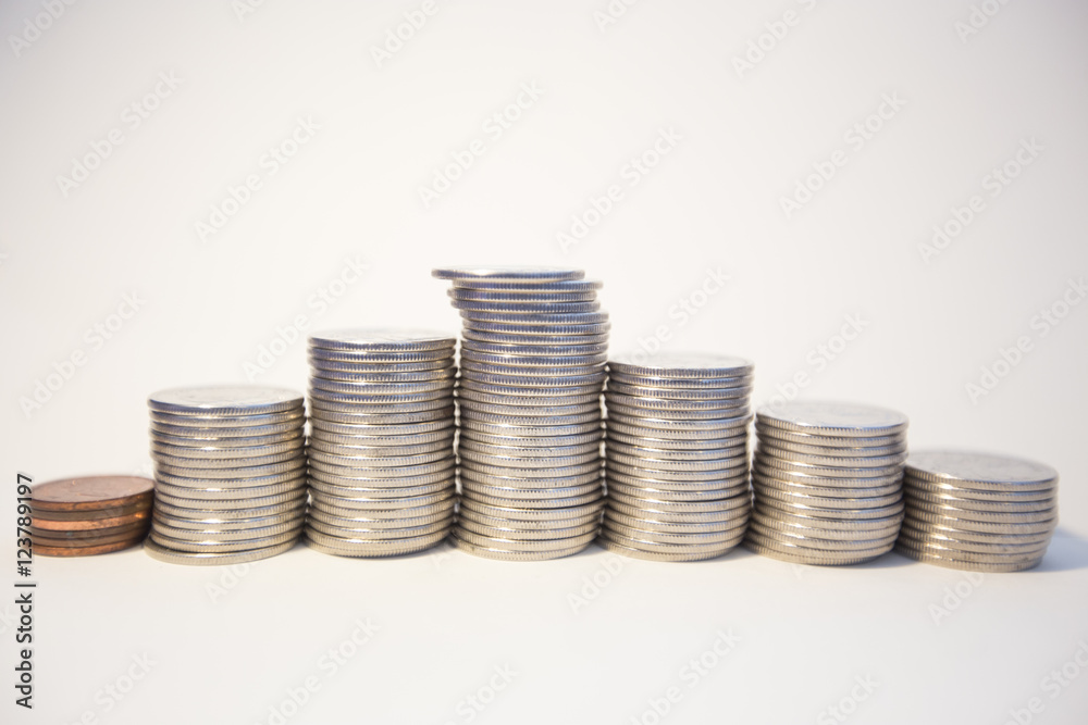 Silver coins stacked on a white background signifying various metaphors for finance and economics Silver coins stacked on a white background signifying various metaphors for finance and economics
