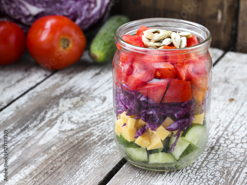 Healthy homemade mason jar salad with cucumber, cheese, tomato,