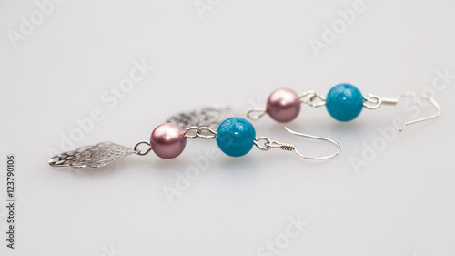 Silver jewels with colorful precious stones and light grey background
