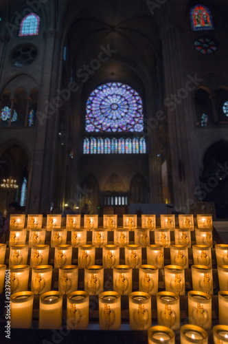 Burning candles in a painted glass in Notre-Dame de Paris.