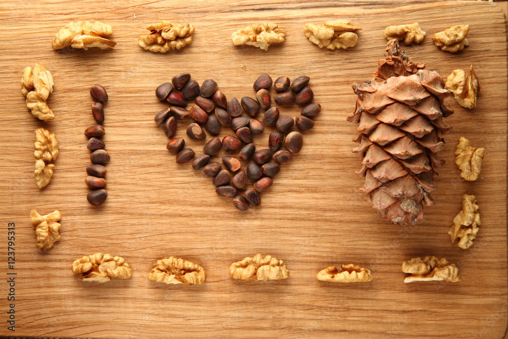 Walnut and pine nuts on a cutting board made of oak/ Walnut and pine nuts on a cutting board made of oak Walnut and pine nuts on a cutting board made of oak/ Walnut and pine nuts on a cutting board made of oak
