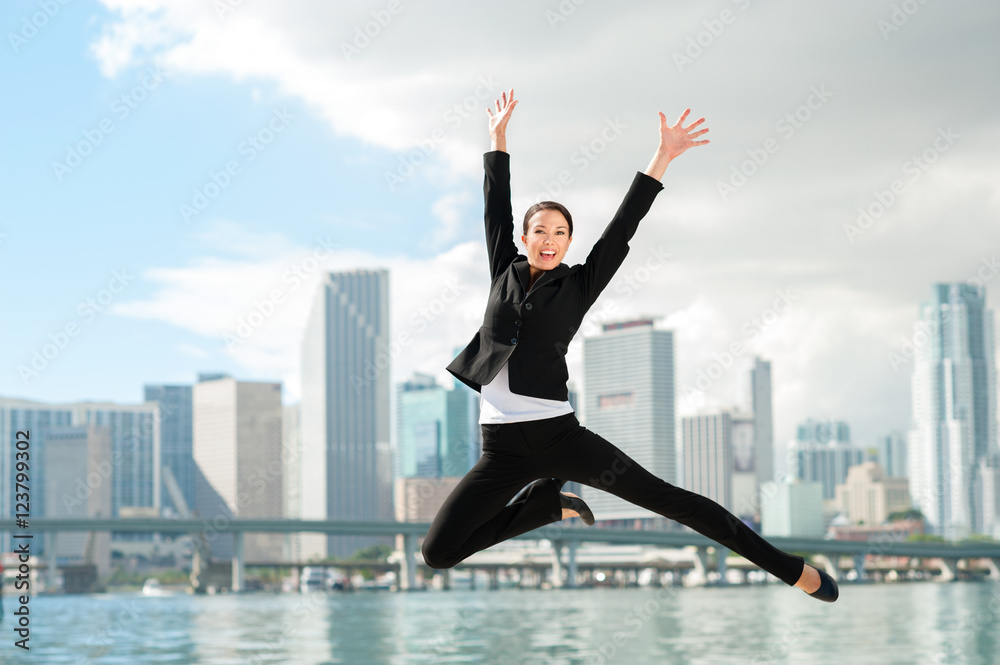 Happy Businesswoman Leaping with Miami Skyline in Background Happy Businesswoman Leaping with Miami Skyline in Background