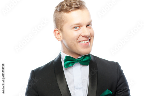 Confident and charisma. Close up portrait of happy young man with bowtie looking at camera isolated on white.