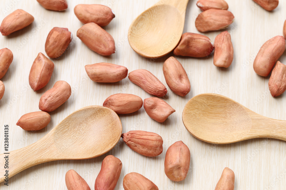 Obraz premium peanut and wooden spoon on wood background.