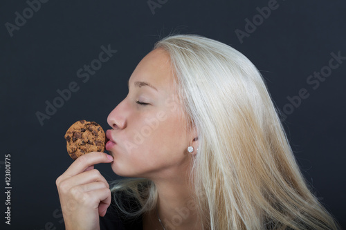 Happy girl kissing a cookie photo